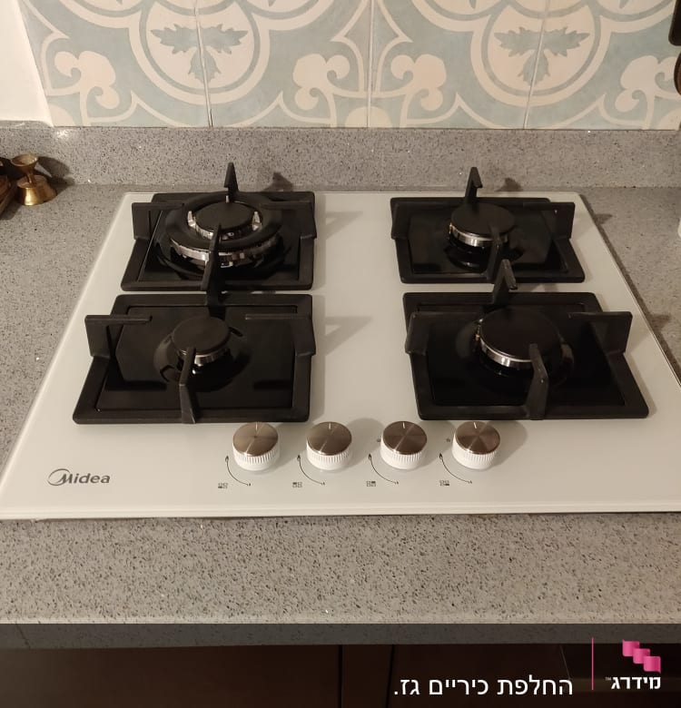 כיריים גז עם ארבעה מבערים וכפתורי שליטה